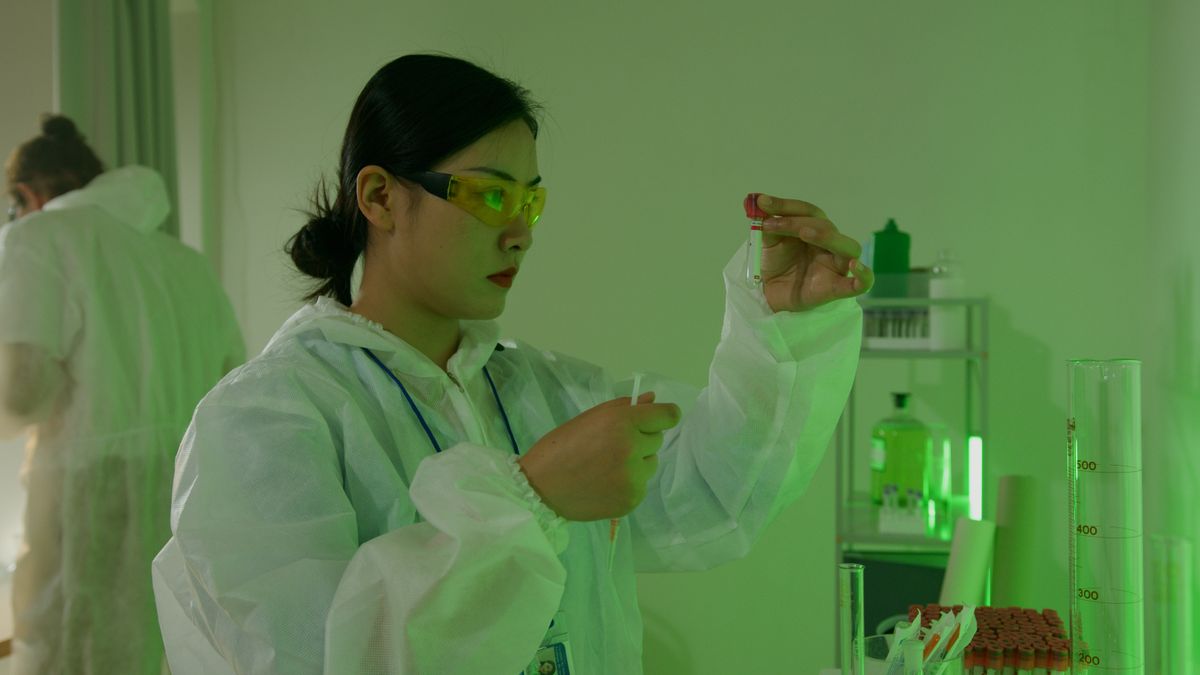 Scientist inspecting a test tube in a laboratory environment, focused on research.