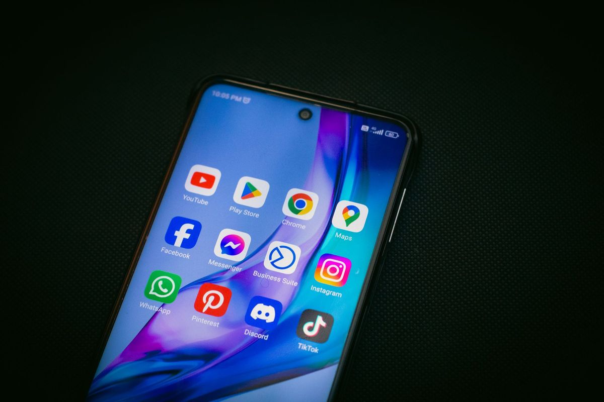 Смартфон з іконками соцмереж у руці