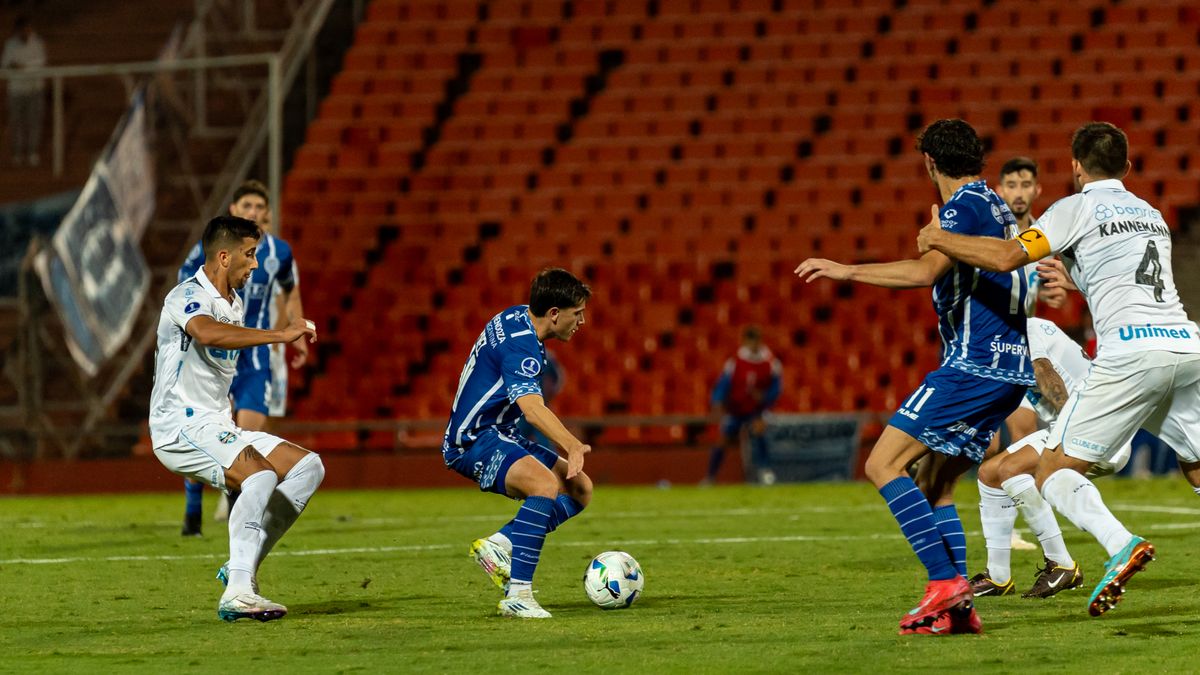 Dynamic action during a nighttime football match with players competing intensely on the field.